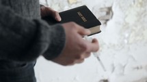 addict holding a needle and a Bible 