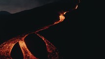 Drone aerial shot of lava flows from volcanic eruption at Pacaya volcano in Guatemala during night-time	