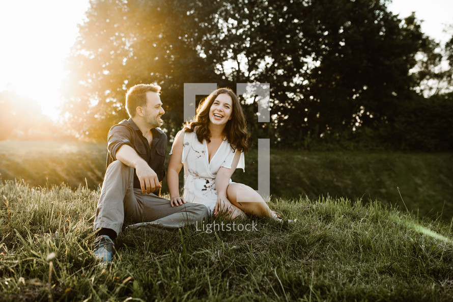 a couple sitting in the grass 
