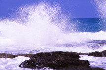 sea crashing into rocks at shore 