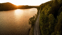 Aerial shot of road among the lakes at sunrise in Scandinavia. 