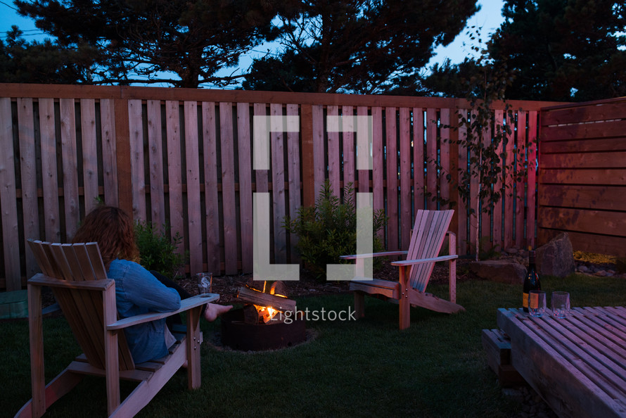 woman sitting by a fire pit 
