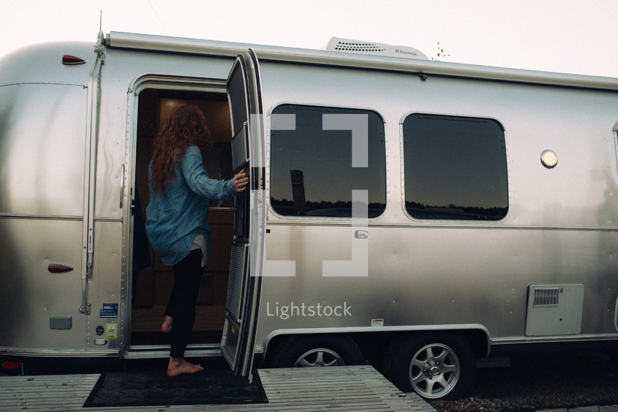 a woman stepping into a camper 
