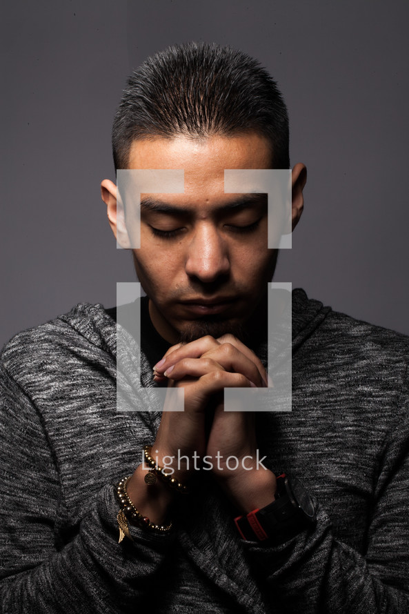 Latino man with head bowed in prayer