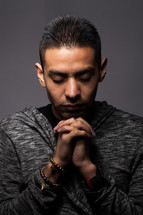 Latino man with head bowed in prayer