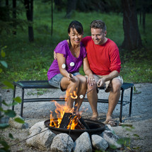 couple roasting marshmallows over a fire 