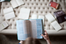 A woman reading from a Bible at a Bible study 