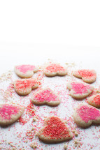 red and pink sprinkles on heart shaped cookies 