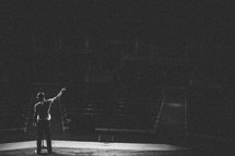 man standing at an altar delivering a sermon to an empty church 