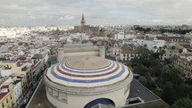 Teatro de la Maestranza with colored striped dome and cathedral in background, Seville in Spain. Aerial panoramic view