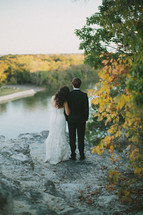 bride and groom looking out at a lake