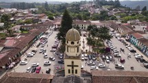 Church Our Lady of Carmen and square in village Salento, Colombia, aerial orbit