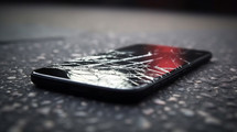 Broken smart phone laying on asphalt. 