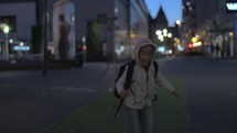 Child having fun and fooling in street at night