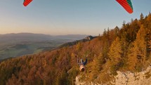 Paragliding flying above autumn forest mountains at beautiful sunset, Freedom  Adrenaline Extreme Sport Adventure
