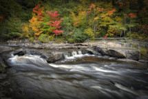 Water moving through rocky stream with fall trees