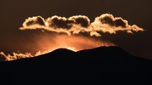 Timelapse of sunset and clouds over mountains