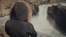 woman watching a waterfall 
