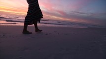 girl walking on a beach at sunset 