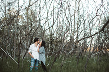 a couple hugging in a forest 