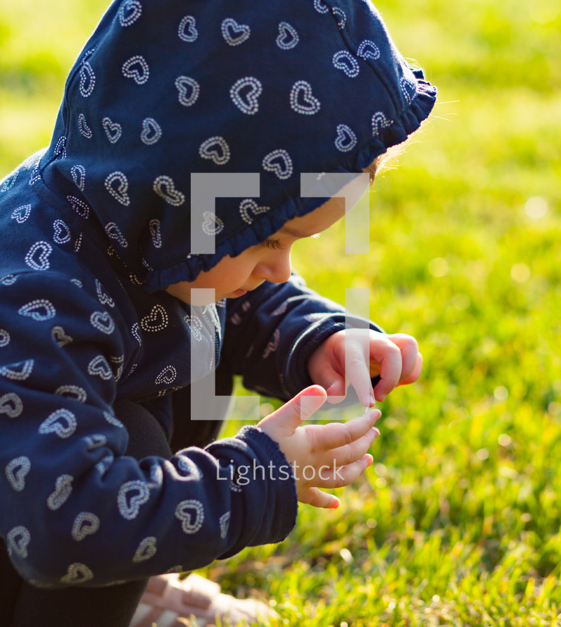toddler girl plays happy in the park outdoors in the spring