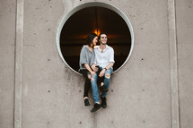a couple sitting in a circular window 