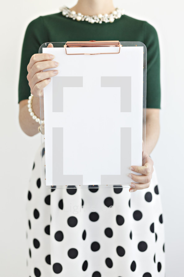 a woman holding a blank clipboard 