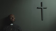 Happy Priest in Cassock Standing in Modern Church and Smiling