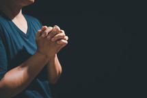 Asian person with hands folded in prayer