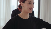 Graceful ballet partners performing fish dive lift together and having talk during rehearsal in a dance studio
