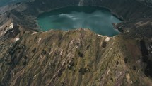 Aerial tilt up shot of Quilotoa Crater Lake inside Volcano during cloudy day in Andes,Ecuador	