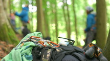 carabiners on a backpack and climbers in a forest 