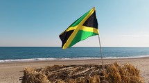 Waving Jamaica Flag On The Beach Near Ocean