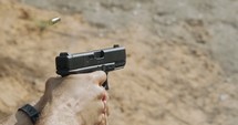 Pistol shooting bullets in super slow motion footage. Hand guns in firing range