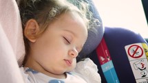 little girl sleeping in her car seat 