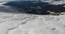 Slow aerial drone shot of Landscape On Top Of The Snowy Mountains In Sinaia, Romania.  