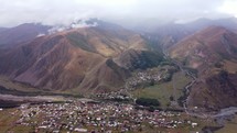 Village in the valley and cloudy mountains