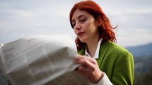 journalist reads newspaper outdoors at sunlight 