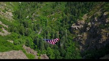 American flag on rope between mountains 