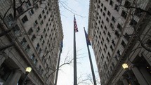 twin downtown matching buildings and flags on a flagpole 
