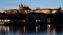 Timelapse of ships on river near Prague Castle at night