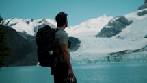 Backpacker Holding Camera, Looking At Glaciers By The Argentino Lake In Patagonia, Argentina. medium shot