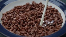 Pouring Milk Over Chocolate Crispies into a Bowl - Slow Motion