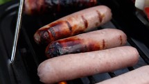 Raw and Cooked Sausages on a Barbecue Grill