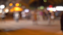 Night street with illumination and walking people, blur