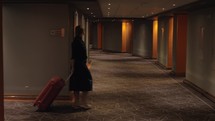 Hotel guest with trolley case walking to the room