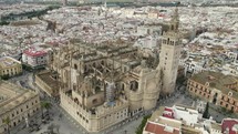 Seville Cathedral with city in background, Spain. Aerial circling
