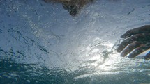 Man is swimming breaststroke style in the open sea water pov shot