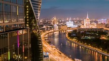 aerial night view of modern skyscrapers and city skyline along illuminated river in russia 4k drone shot