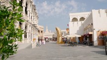 Souq Waqif main street and the golden giant thumb sculpture in background at Doha Qatar
